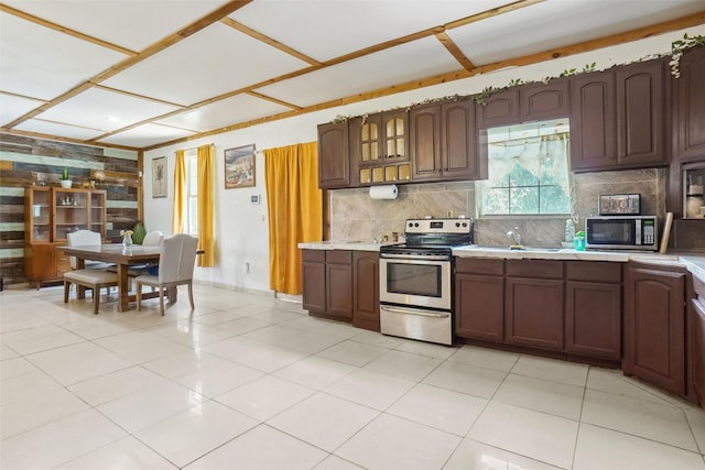 kitchen featuring backsplash, dark brown cabinetry, stainless steel appliances, and light tile patterned floors