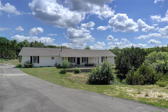 ranch-style house with covered porch and a front lawn