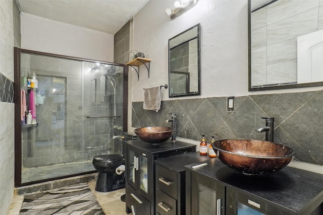 bathroom with vanity, tasteful backsplash, toilet, and a shower with door