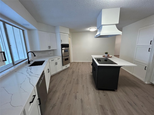 kitchen featuring sink, white cabinetry, light hardwood / wood-style flooring, a kitchen island, and stainless steel appliances