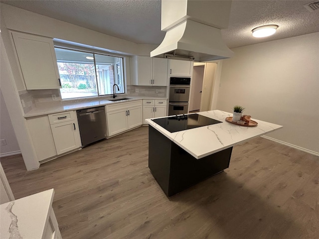 kitchen with white cabinets, a kitchen island, sink, and appliances with stainless steel finishes