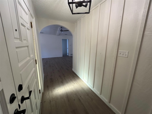 hallway with dark hardwood / wood-style flooring and a textured ceiling