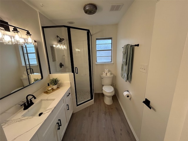 bathroom featuring hardwood / wood-style flooring, vanity, plenty of natural light, and walk in shower