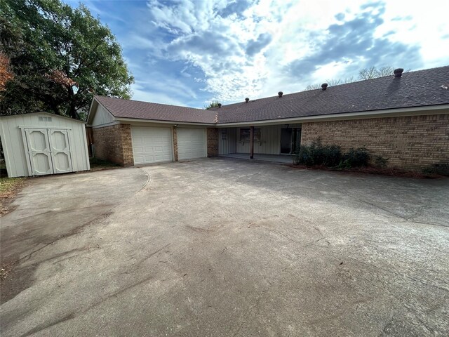 ranch-style house with a storage unit and a garage