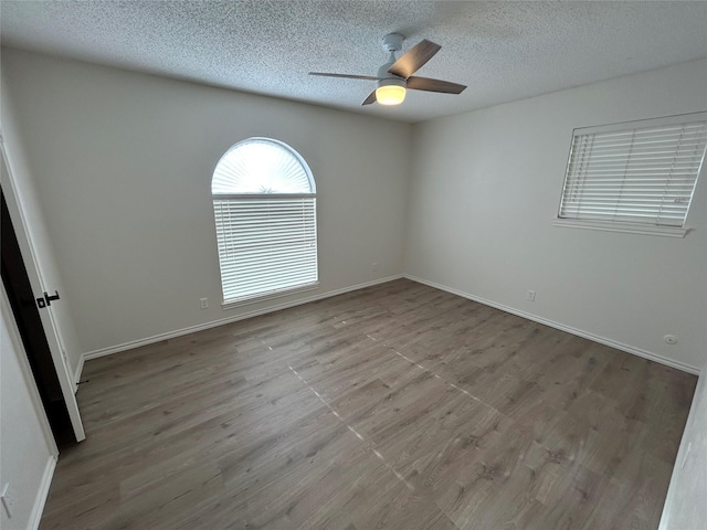 empty room featuring a textured ceiling, ceiling fan, and light wood-type flooring