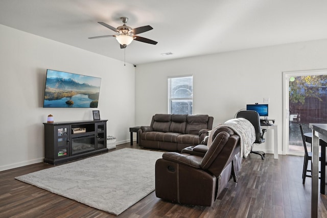 living room with ceiling fan and dark wood-type flooring