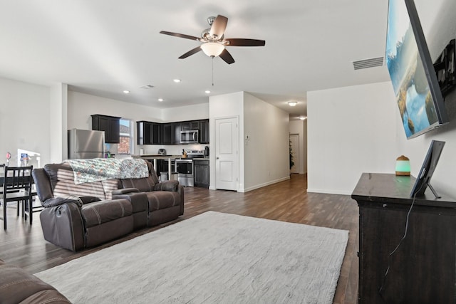 living room with dark wood-type flooring and ceiling fan