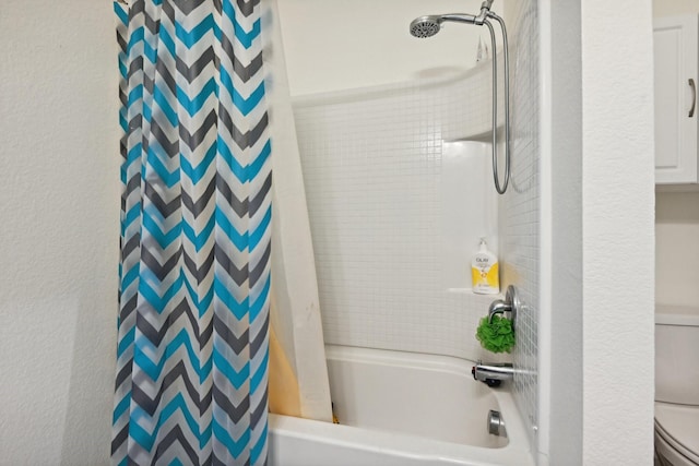 bathroom featuring shower / tub combo and toilet