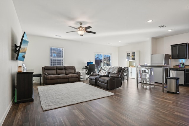 living room featuring ceiling fan and dark wood-type flooring