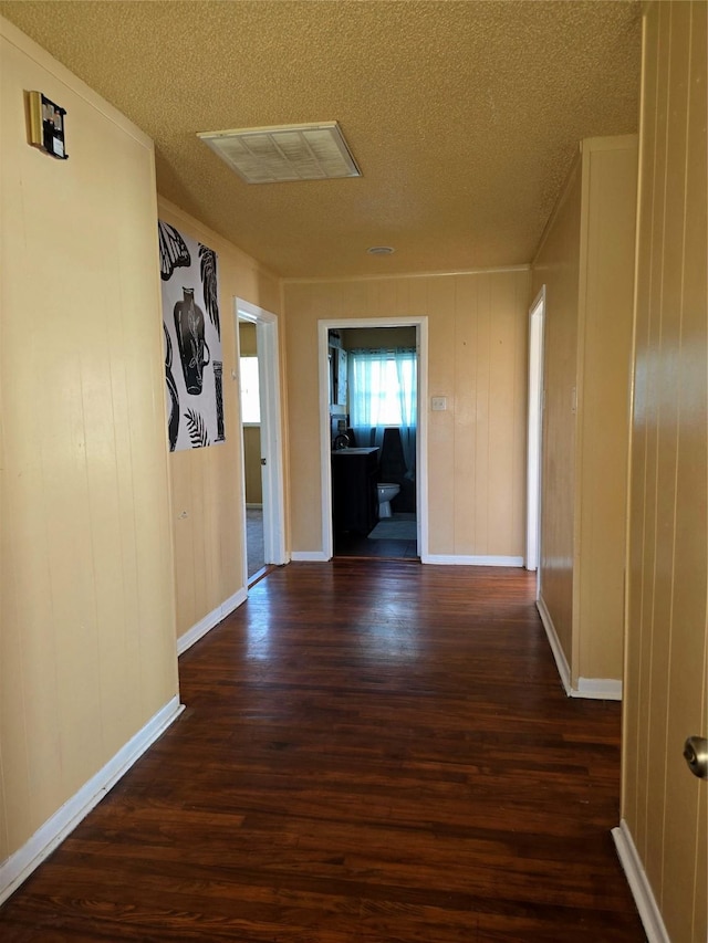 hallway with dark wood-type flooring and a textured ceiling