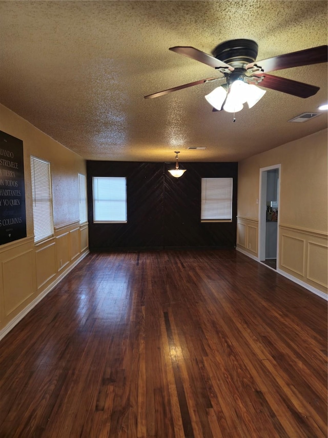 unfurnished room featuring ceiling fan, dark hardwood / wood-style floors, and a textured ceiling