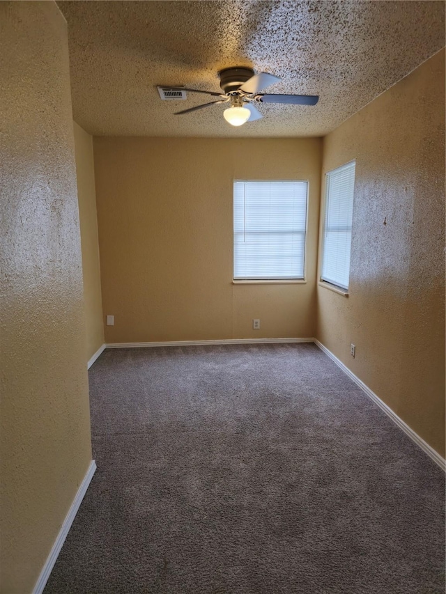 carpeted spare room featuring ceiling fan and a textured ceiling