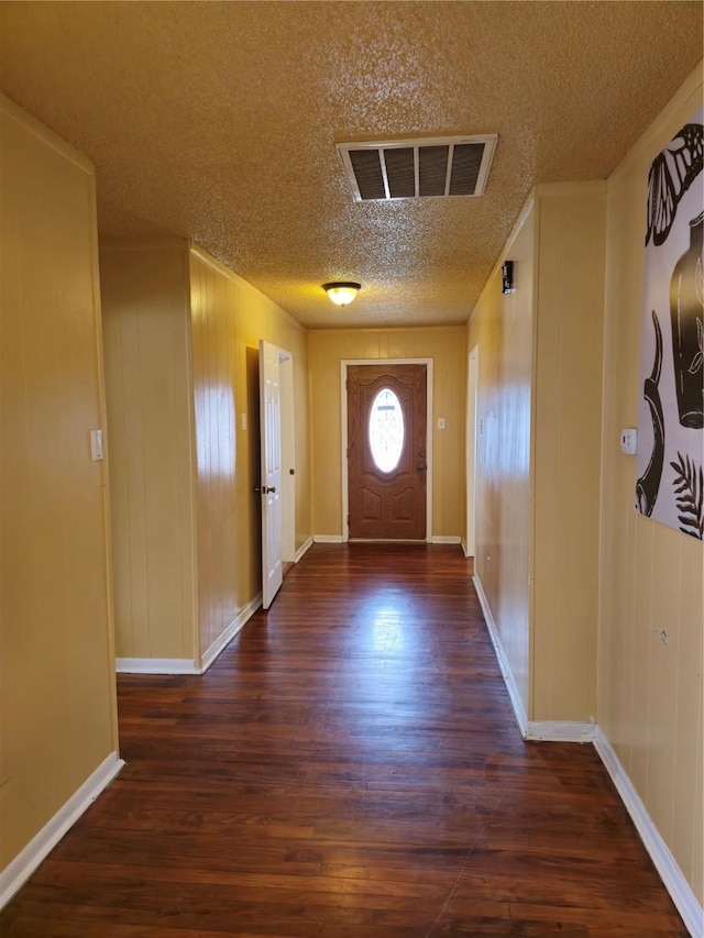 doorway with dark hardwood / wood-style flooring and a textured ceiling