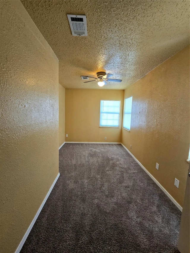 carpeted spare room with a textured ceiling and ceiling fan