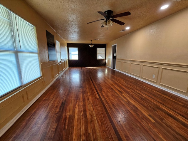 spare room with ceiling fan, dark hardwood / wood-style floors, and a textured ceiling