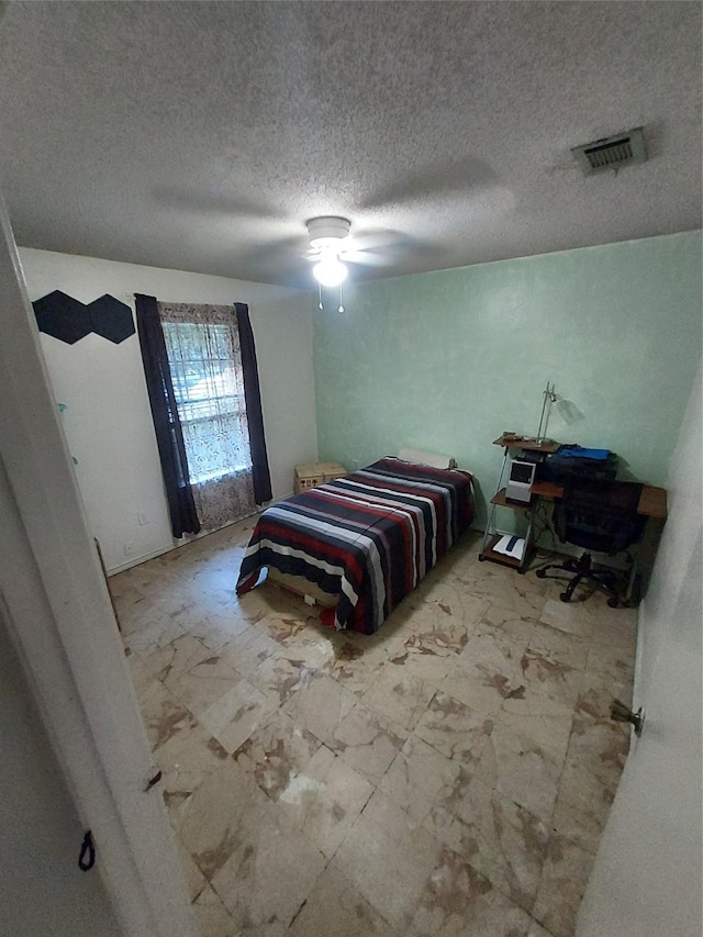 bedroom featuring a textured ceiling and ceiling fan