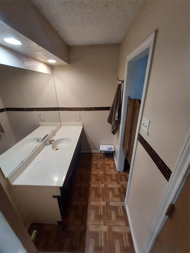 bathroom featuring vanity, a textured ceiling, and parquet floors