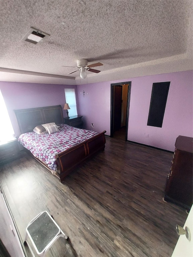 bedroom featuring a textured ceiling, multiple windows, ceiling fan, and dark hardwood / wood-style floors