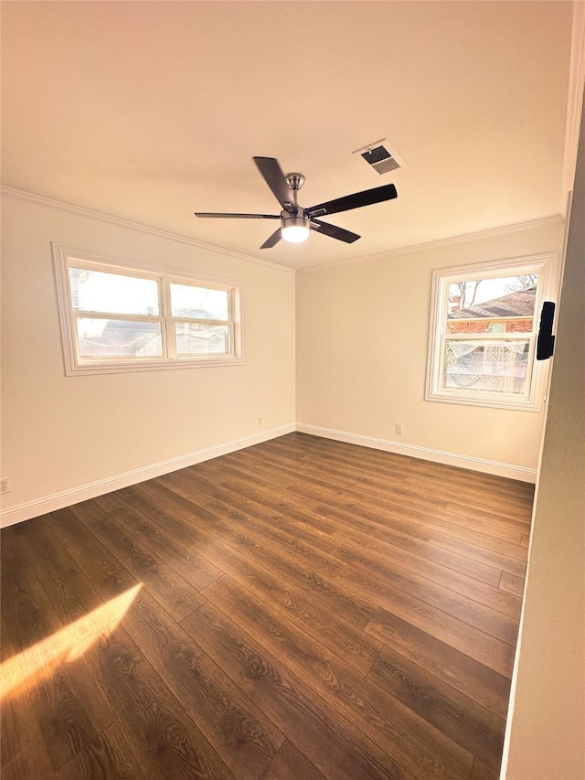 empty room featuring ceiling fan, dark wood-type flooring, and ornamental molding