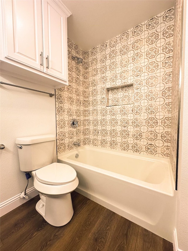 bathroom featuring wood-type flooring, shower / bathtub combination, and toilet