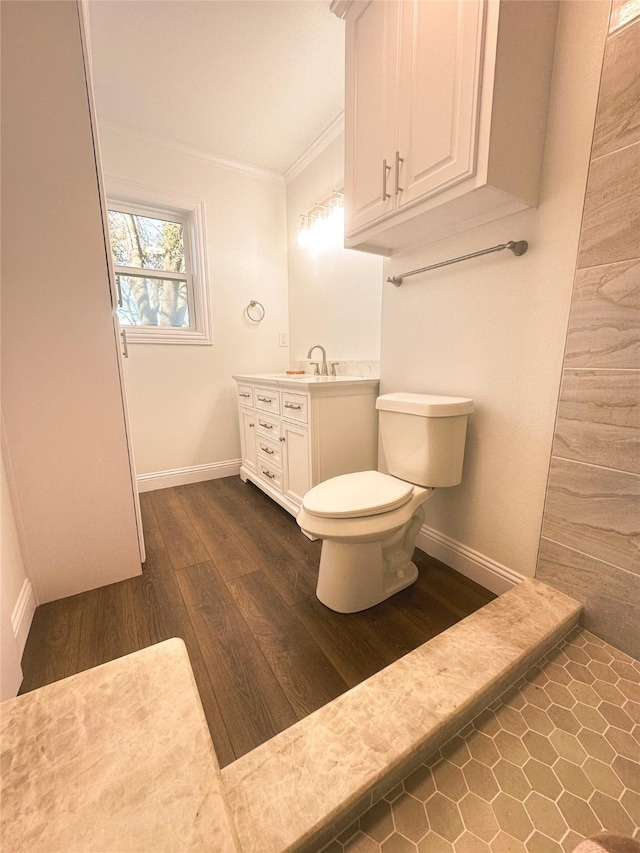 bathroom featuring hardwood / wood-style flooring, toilet, vanity, and crown molding