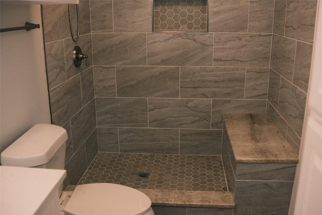 bathroom with toilet and a tile shower