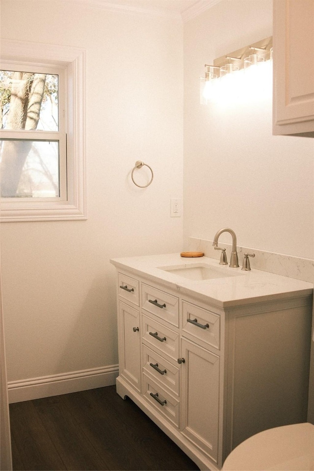 bathroom featuring hardwood / wood-style flooring, vanity, and ornamental molding