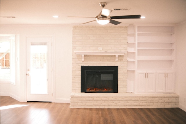 unfurnished living room with ceiling fan, a fireplace, and hardwood / wood-style flooring