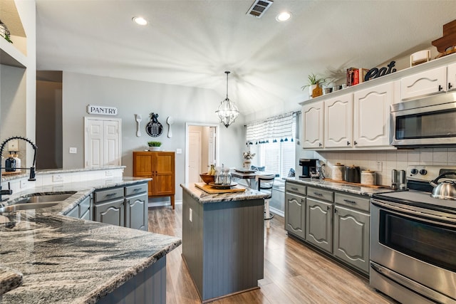 kitchen featuring white cabinets, sink, gray cabinets, dark stone countertops, and appliances with stainless steel finishes