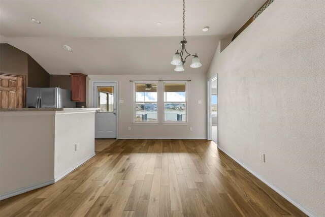 interior space featuring a chandelier, lofted ceiling, and hardwood / wood-style flooring