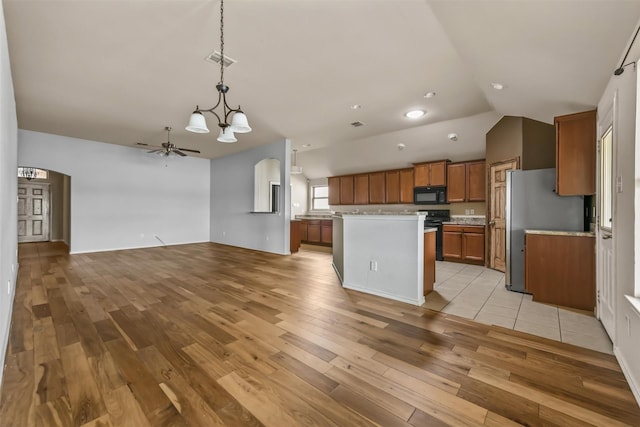 kitchen featuring decorative light fixtures, a center island, ceiling fan, light hardwood / wood-style floors, and black appliances