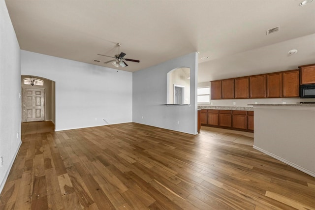 unfurnished living room with ceiling fan and light wood-type flooring