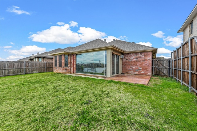 rear view of house with a yard and a patio