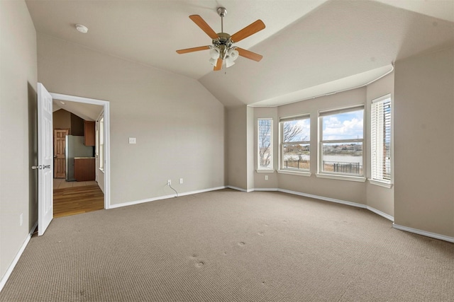 unfurnished room featuring ceiling fan, vaulted ceiling, and light carpet