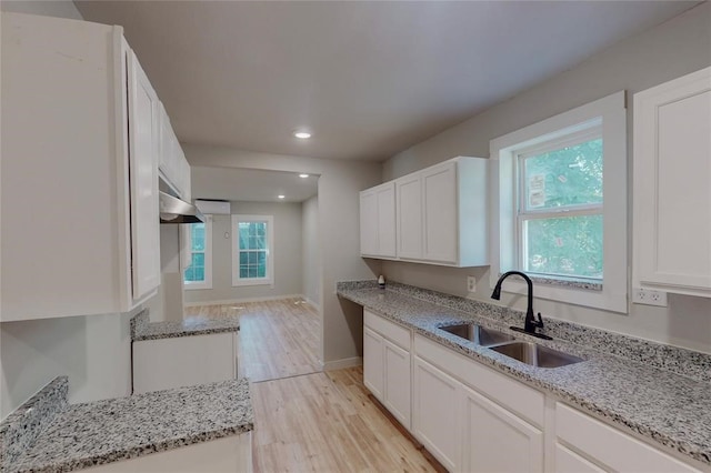 kitchen with sink, white cabinets, plenty of natural light, and light hardwood / wood-style flooring