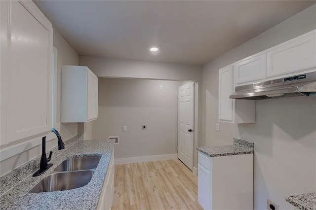 kitchen featuring light stone counters, sink, light hardwood / wood-style floors, white cabinetry, and range hood