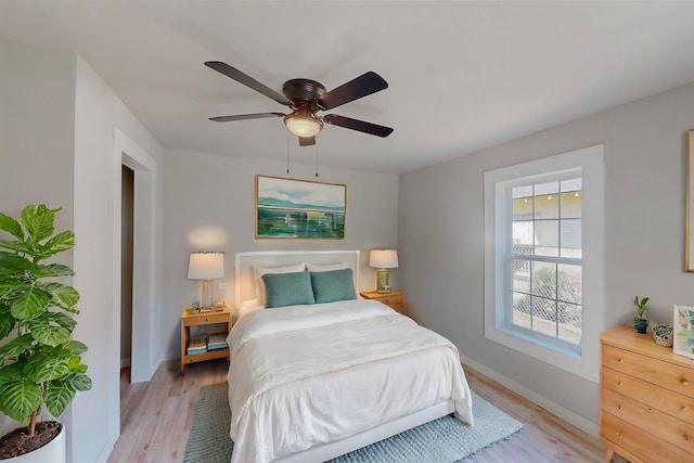 bedroom with ceiling fan and light hardwood / wood-style floors