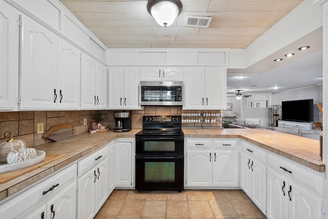 kitchen featuring white cabinetry, double oven range, and tasteful backsplash