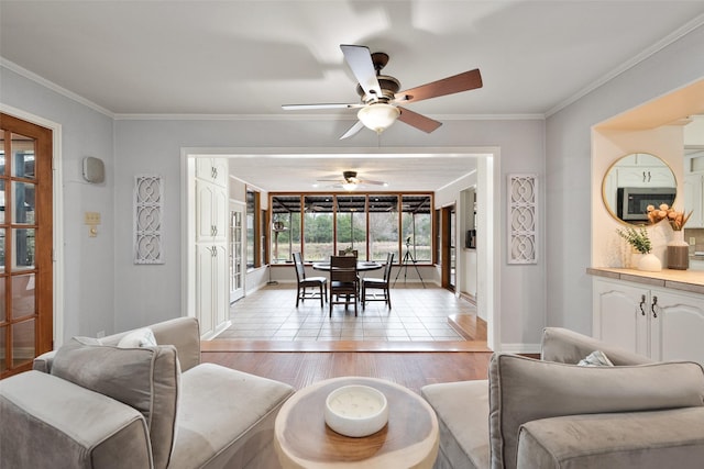 living room with light hardwood / wood-style flooring, ornamental molding, and ceiling fan