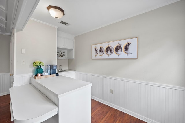 interior space featuring crown molding, dark wood-type flooring, and indoor wet bar