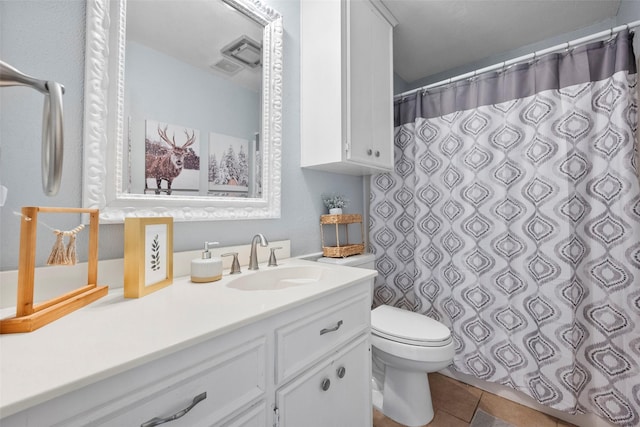 bathroom with tile patterned flooring, vanity, and toilet