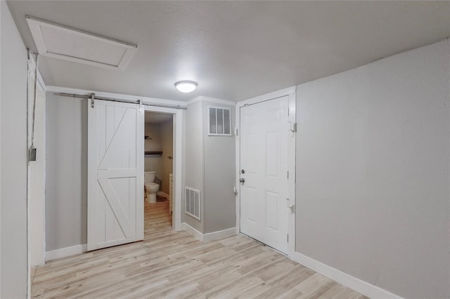 interior space featuring a barn door and light wood-type flooring