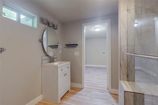 bathroom featuring wood-type flooring, vanity, and a shower with shower door