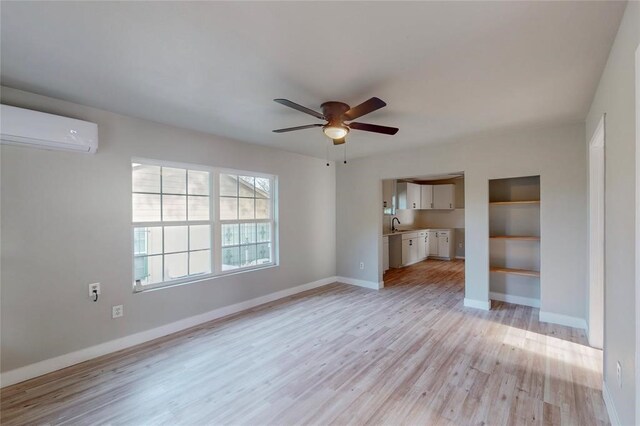 unfurnished living room with light wood-type flooring, a wall mounted AC, and ceiling fan