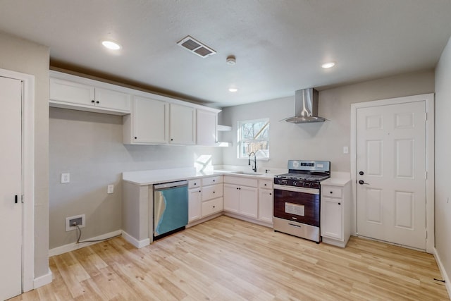 kitchen featuring sink, stainless steel appliances, wall chimney range hood, light hardwood / wood-style flooring, and white cabinets