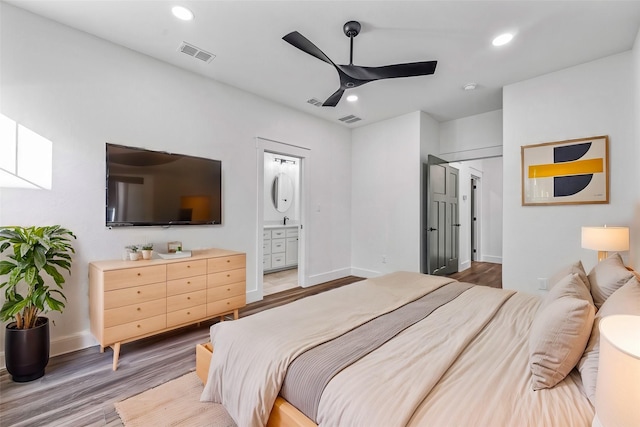 bedroom with wood-type flooring, ensuite bathroom, and ceiling fan