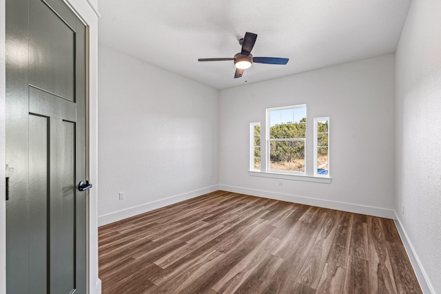 unfurnished room with dark wood-type flooring and ceiling fan