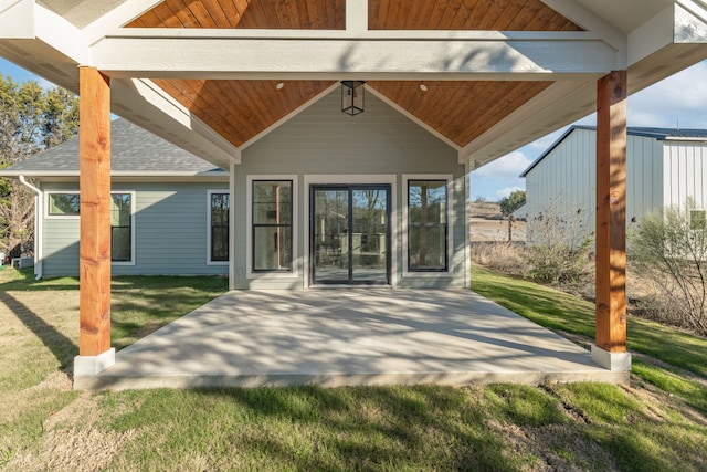 back of house with a patio area and a lawn