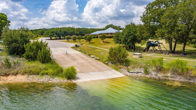 surrounding community with a water view and a playground