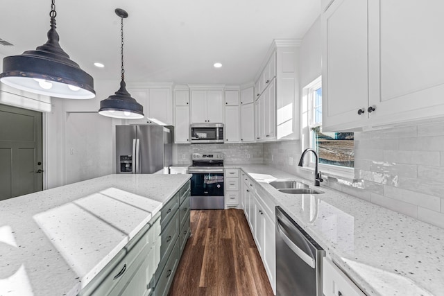 kitchen featuring pendant lighting, sink, white cabinetry, stainless steel appliances, and light stone countertops